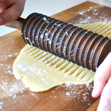 Load image into Gallery viewer, noodle cutter rolling out dough on a cutting board